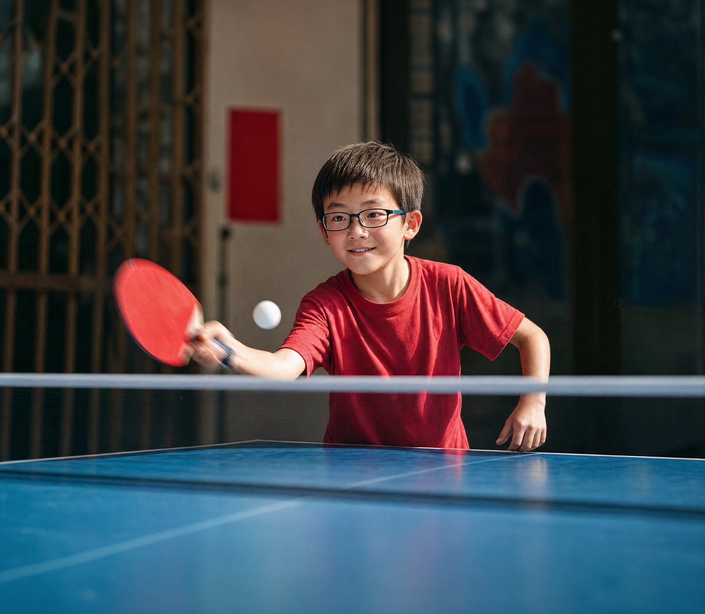 Boy wearing MiYOSMART spectacles playing table tennis